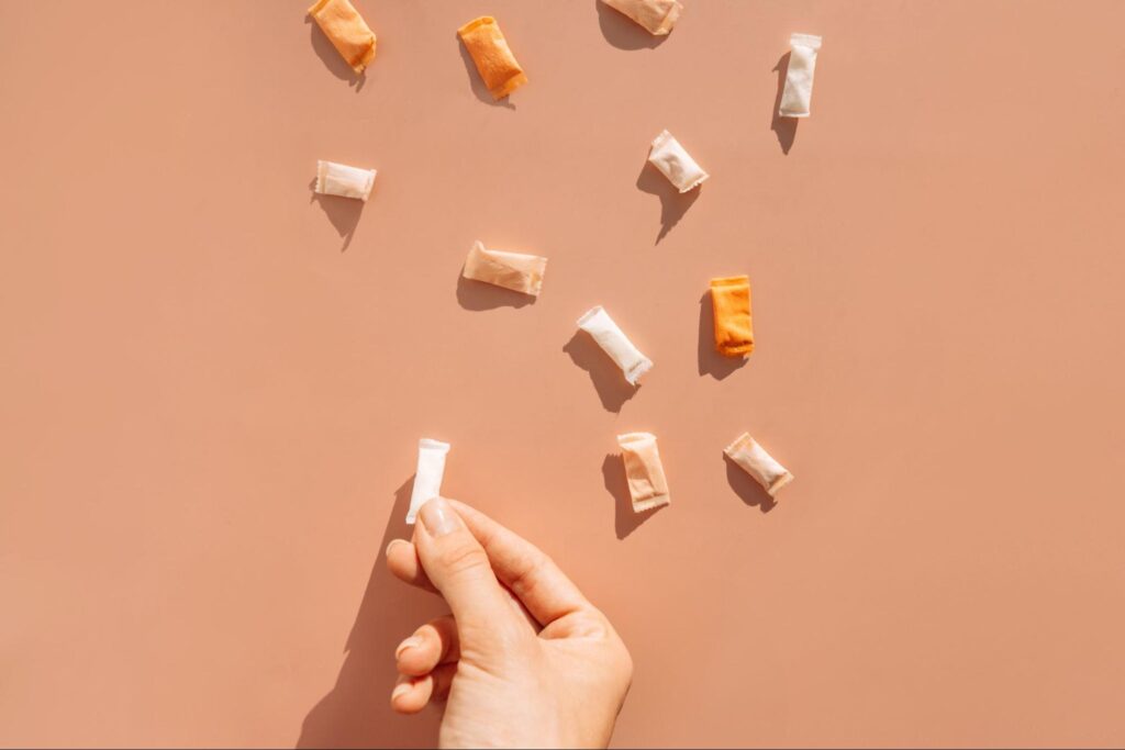 womans hand holding tobacco and tobacco free pouches