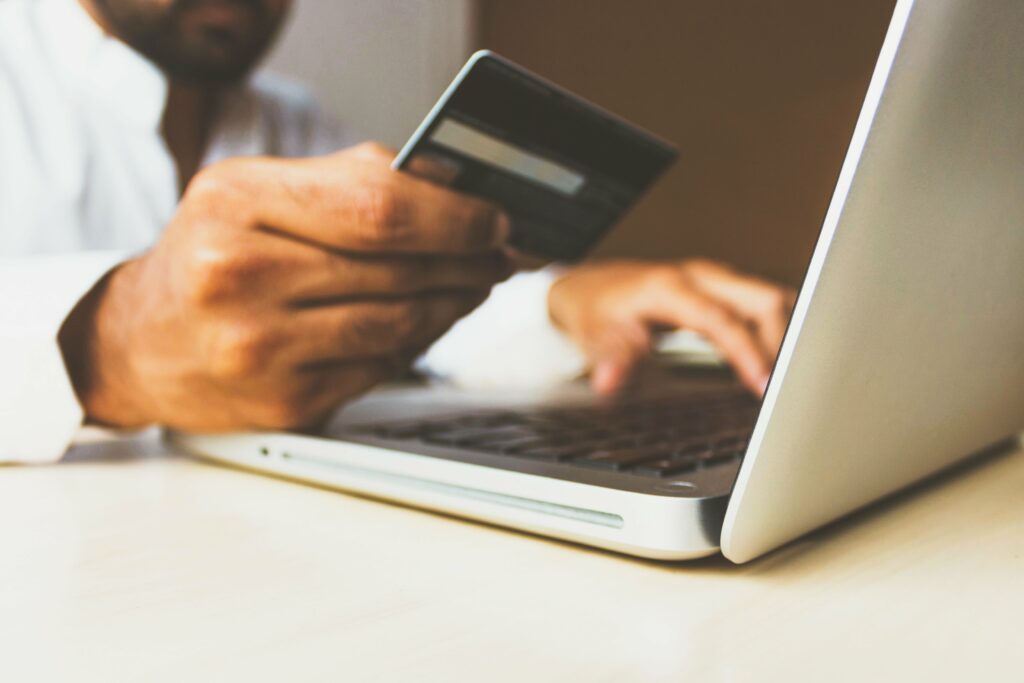 person holding credit card at laptop