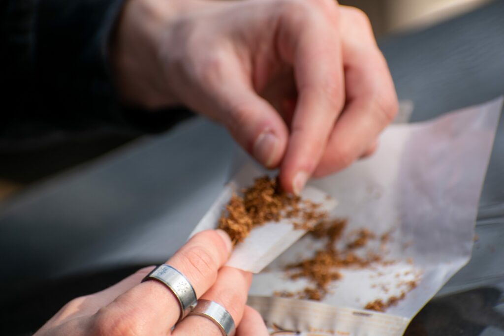 hands rolling tobacco in rolling papers