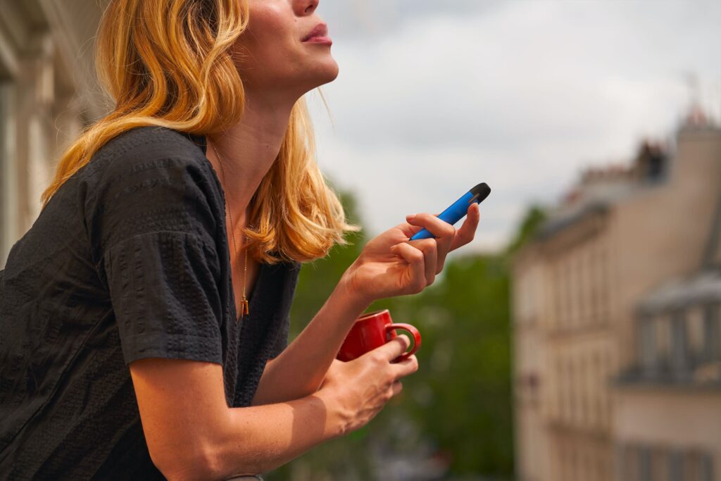 person on balcony vaping