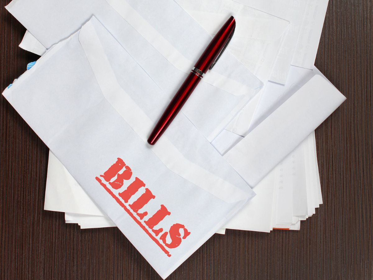 envelopes on table that say "bills" in red.