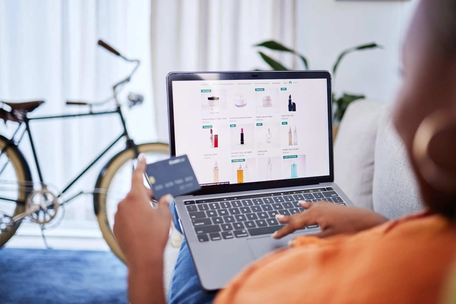 a person holding a credit card and using a laptop
