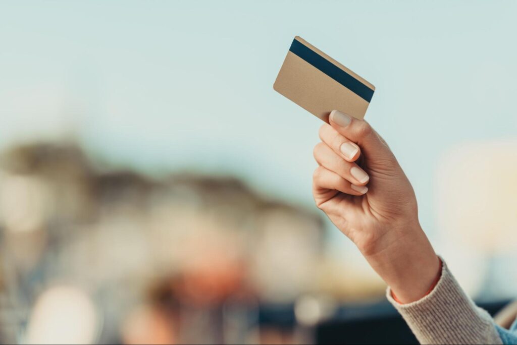 a hand holding a visa credit card for the VAMP program