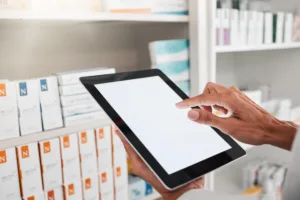 Pharmacist using a tablet to manage inventory, representing VIPPS-accredited online pharmacy payment processing